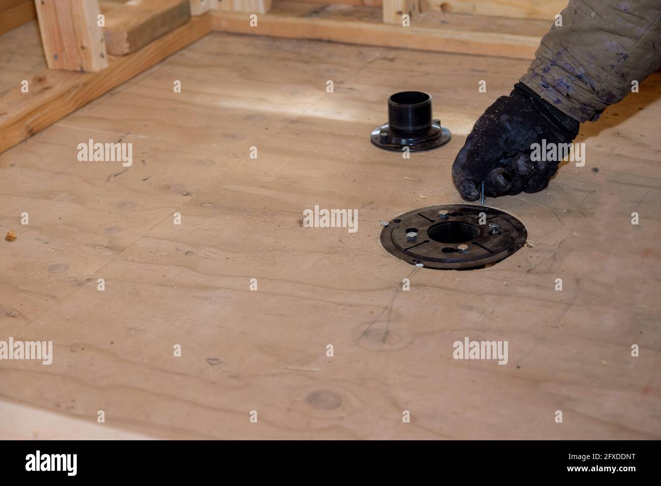 Plombier d'installation de joints de tuyaux d'évacuation de douche d'égout sur une maison en construction Banque D'Images