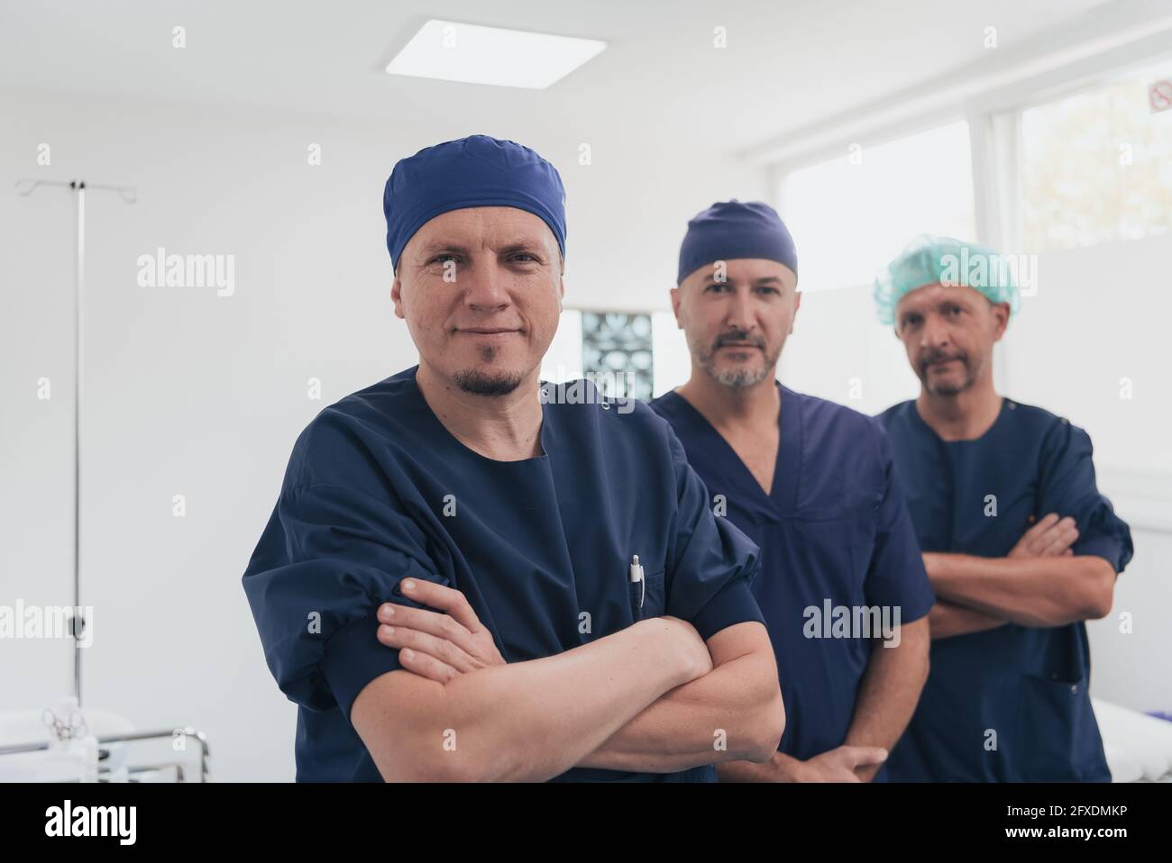 Médecin orthopédique multiethnique devant son équipe médicale à l'appareil photo portant un masque facial Banque D'Images