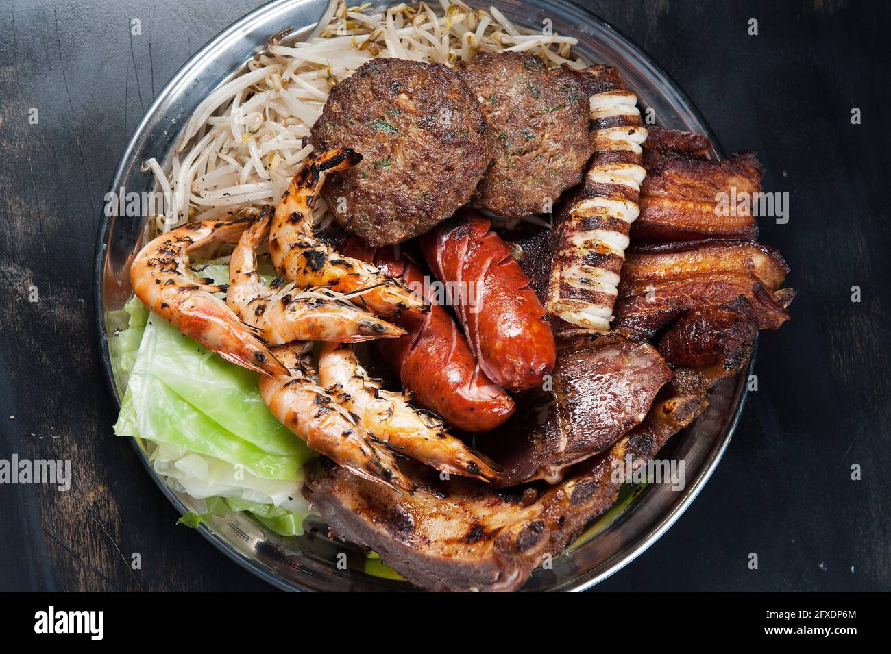 Assiette de plats asiatiques. Crevettes grillées, viandes de bœuf, pieuvre et ventre de porc. Banque D'Images