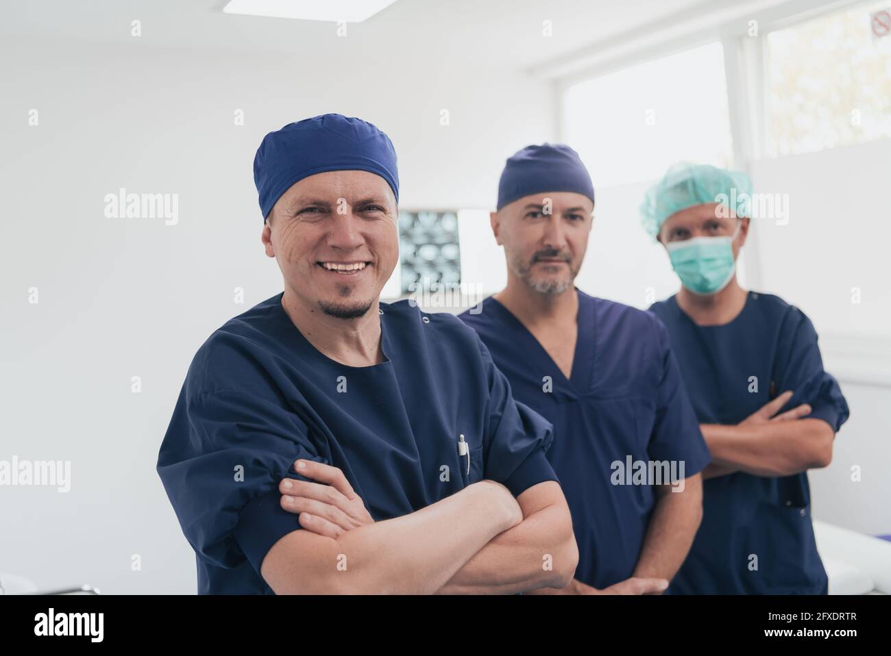 Médecin orthopédique multiethnique devant son équipe médicale à l'appareil photo portant un masque facial Banque D'Images