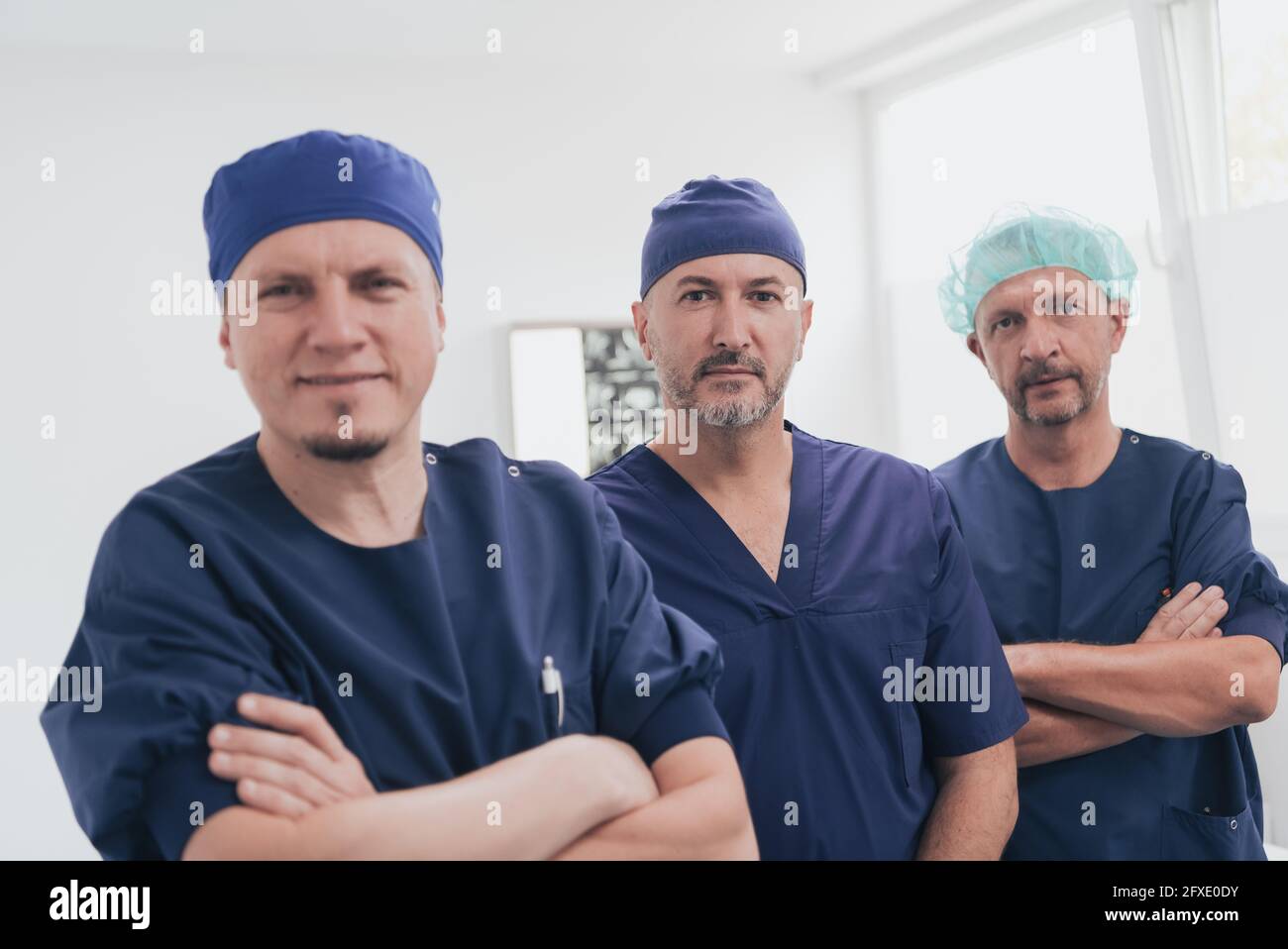 Médecin orthopédique multiethnique devant son équipe médicale à l'appareil photo portant un masque facial Banque D'Images