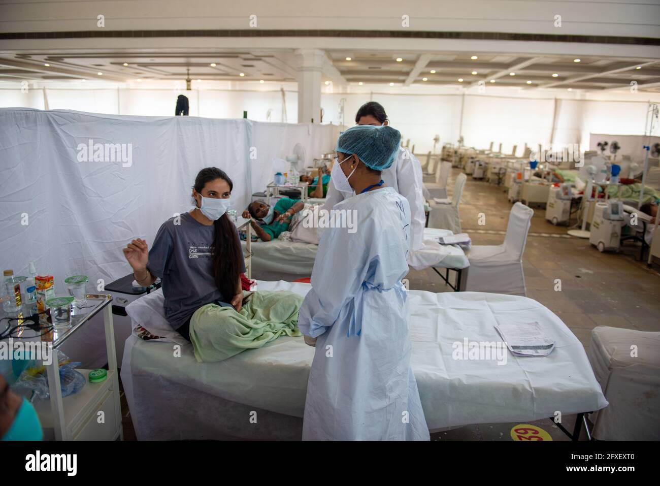 New Delhi, Inde. 26 mai 2021. Un professionnel de la santé portant un équipement de protection individuelle (EPI) a vu parler à un patient Covid-19 au Sri Guru Tegh Bahadar Covid-19 Medical isolation & Treatment Centre, à Gurdwara Rakab Ganj Sahib. Delhi Sikh Gurdwara Comité de gestion dirigez un centre de soins Covid-19 avec l'aide de l'organisation internationale des droits de l'homme et du gouvernement de Delhi. Le 26 mai 2021 24, 95,591 cas actifs ont été enregistrés en Inde selon le site Web du ministère de la Santé. Crédit : SOPA Images Limited/Alamy Live News Banque D'Images