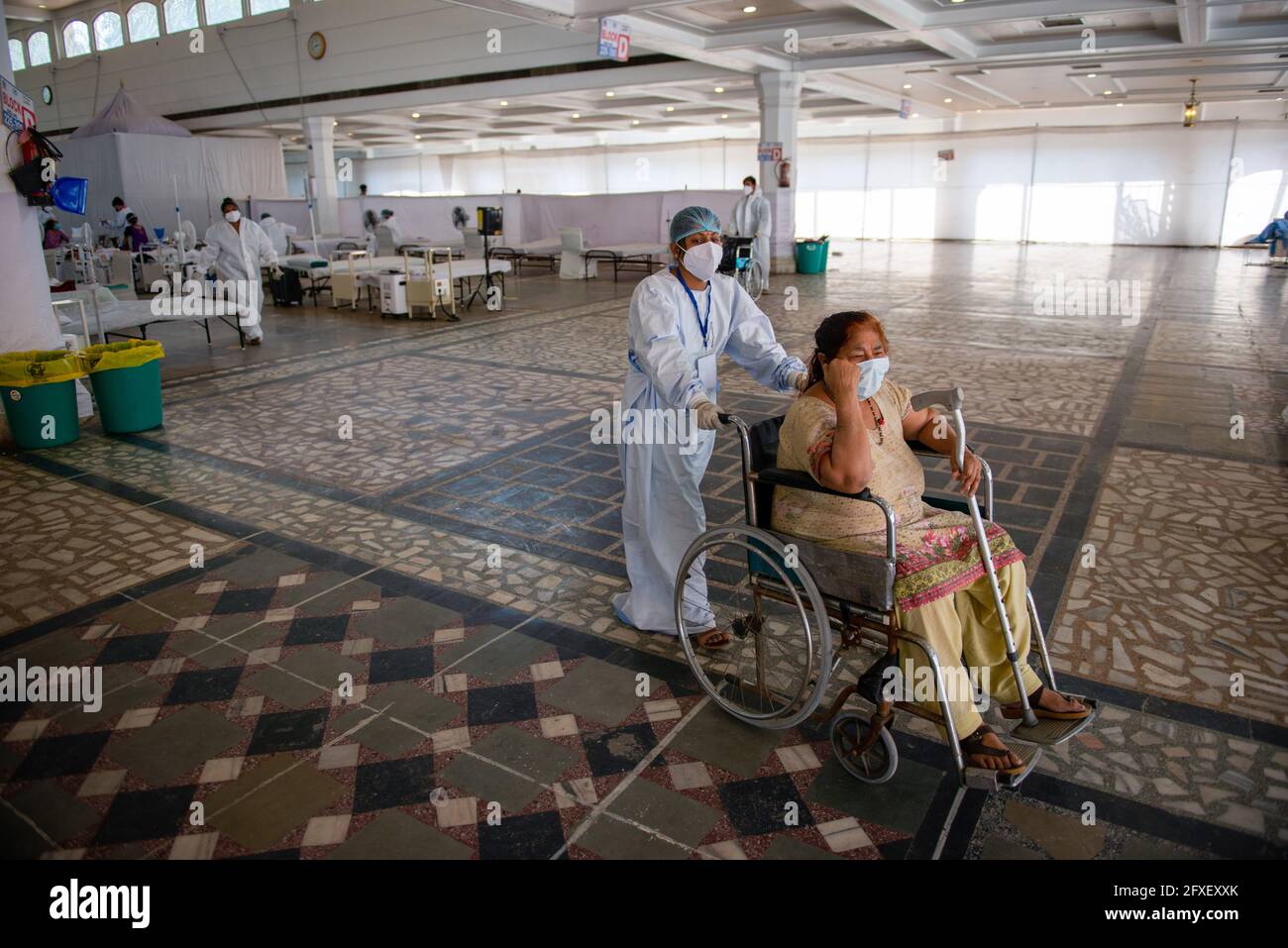 New Delhi, Inde. 26 mai 2021. Un agent de santé a vu aider un patient âgé en fauteuil roulant au Sri Guru Tegh Bahadar Covid-19 Medical isolation & Treatment Centre, à Gurdwara Rakab Ganj Sahib. Delhi Sikh Gurdwara Comité de gestion dirigez un centre de soins Covid-19 avec l'aide de l'organisation internationale des droits de l'homme et du gouvernement de Delhi. Le 26 mai 2021 24, 95,591 cas actifs ont été enregistrés en Inde selon le site Web du ministère de la Santé. Crédit : SOPA Images Limited/Alamy Live News Banque D'Images