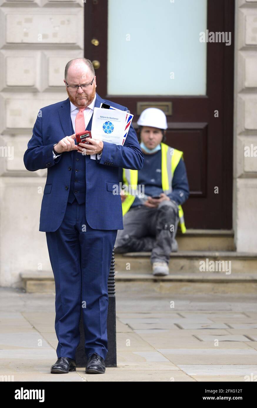 George Freeman MP (con: Mid Norfolk) sur son téléphone portable à Whitehall, le 26 mai 2021, tenant le papier "réforme pour la résilience" par le P post-pandémique Banque D'Images