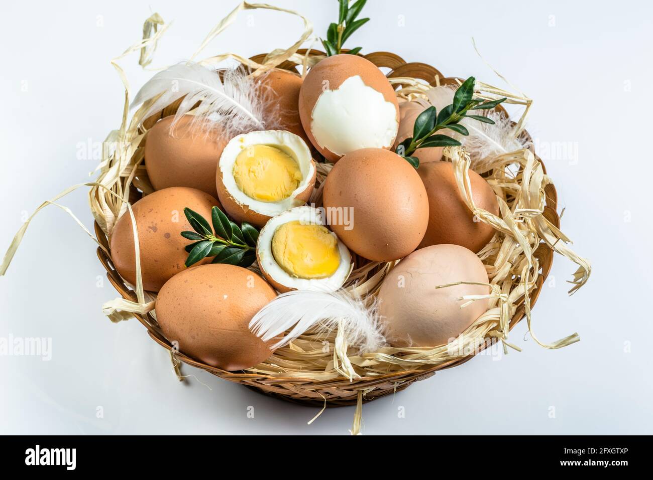 Œufs frais de ferme dans le panier et œuf dur isolé sur fond blanc, concept de pâques Banque D'Images