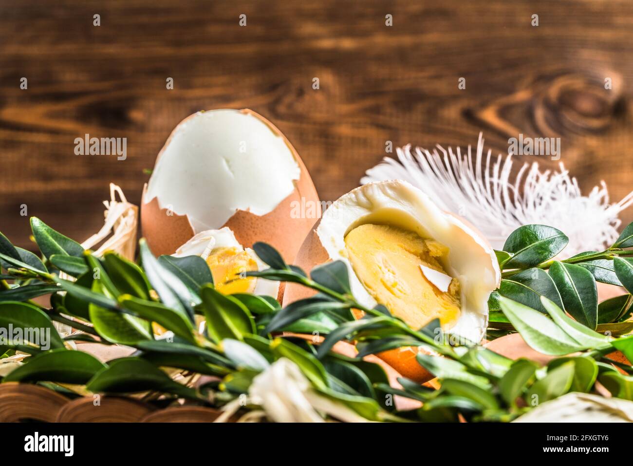 Œufs frais de ferme dans le panier et œuf dur, fond de pâques Banque D'Images