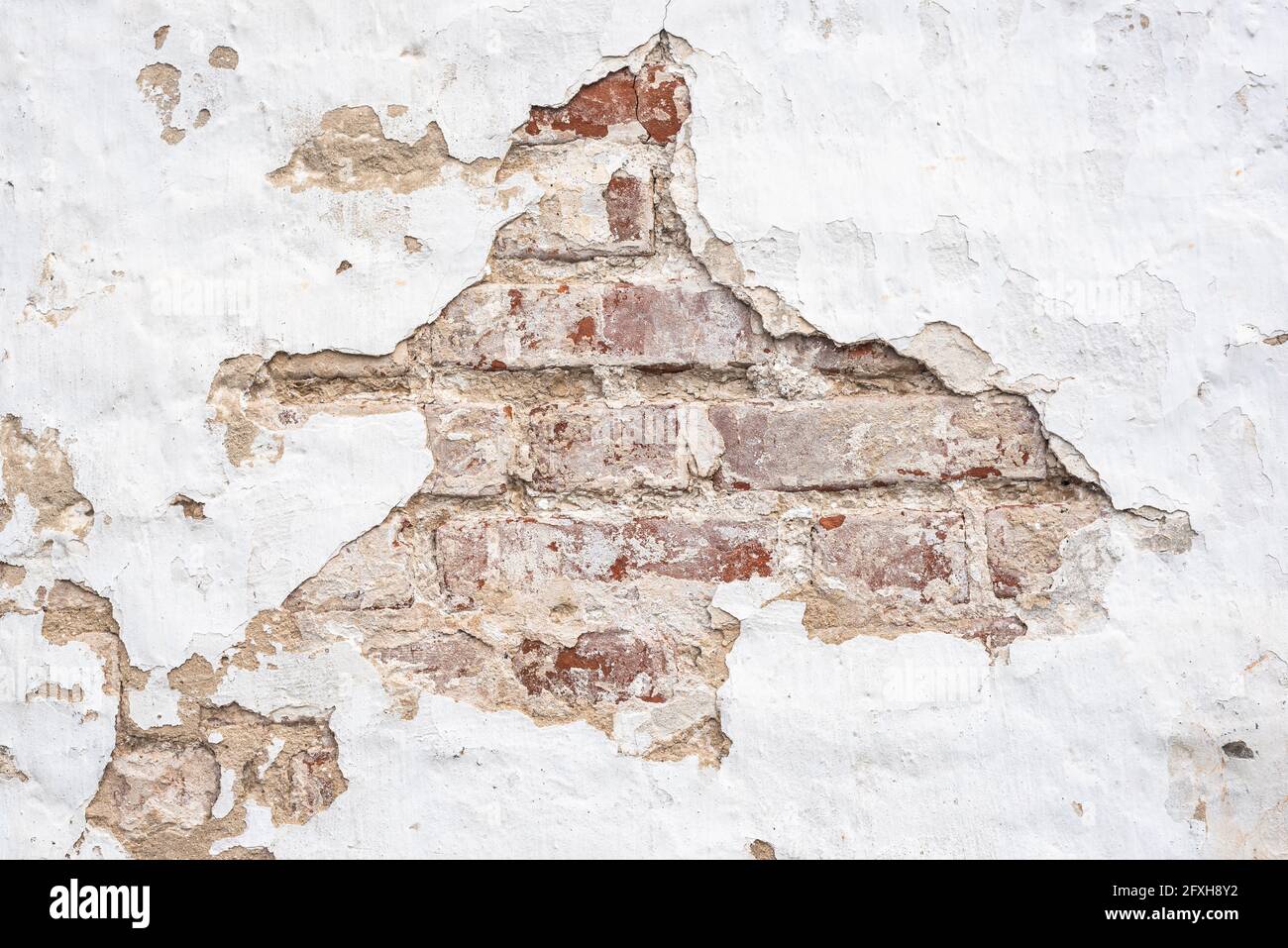 Mur de l'ancien bâtiment avec grand trou en blanc ébréché stuc Banque D'Images