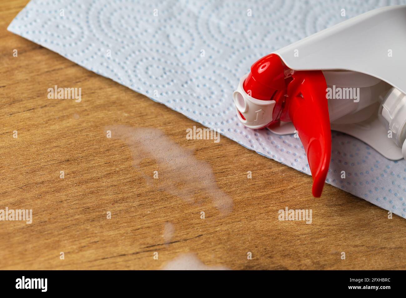 Une serviette en papier et une bouteille avec un atomiseur avec un liquide  pour nettoyer les meubles et les fenêtres. Photo prise sous une lumière  artificielle douce Photo Stock - Alamy