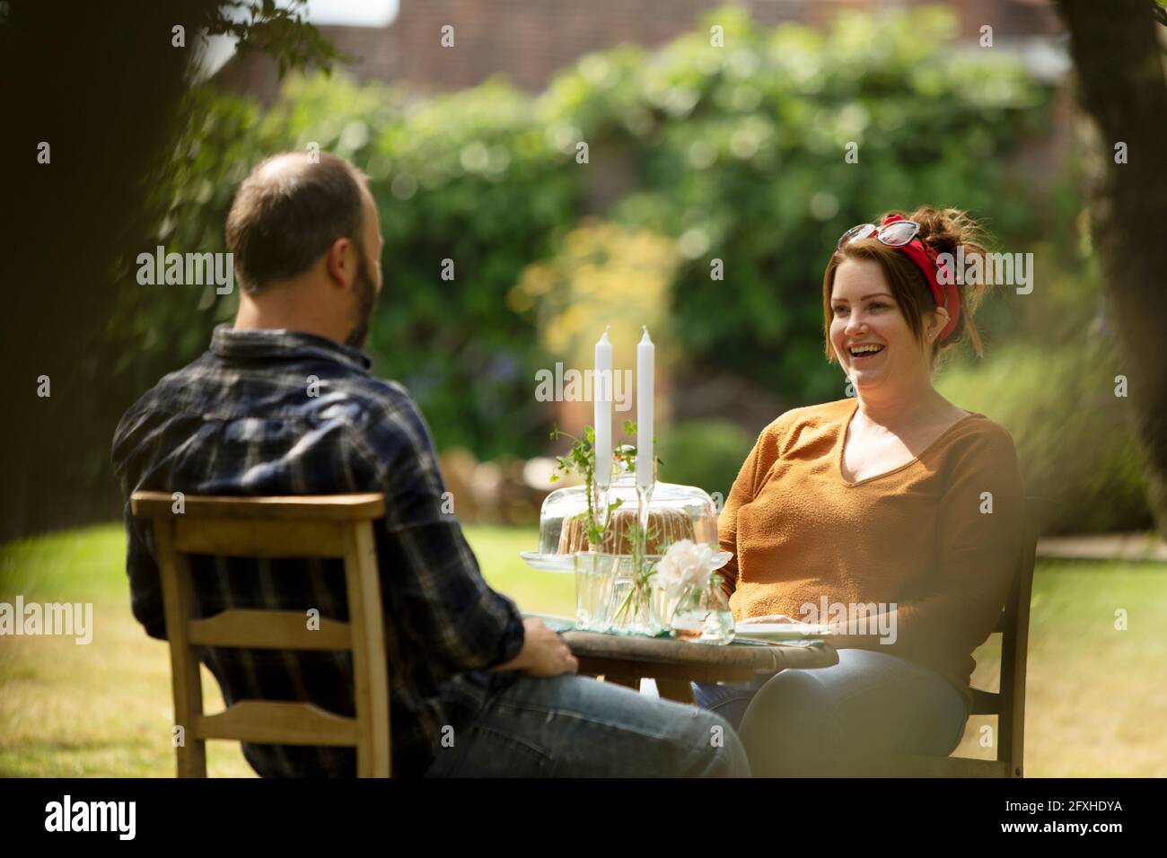Couple heureux en train de déguster un gâteau à la table du jardin d'été Banque D'Images Couple heureux en train de déguster un gâteau à la table du jardin d'été Banque D'Images