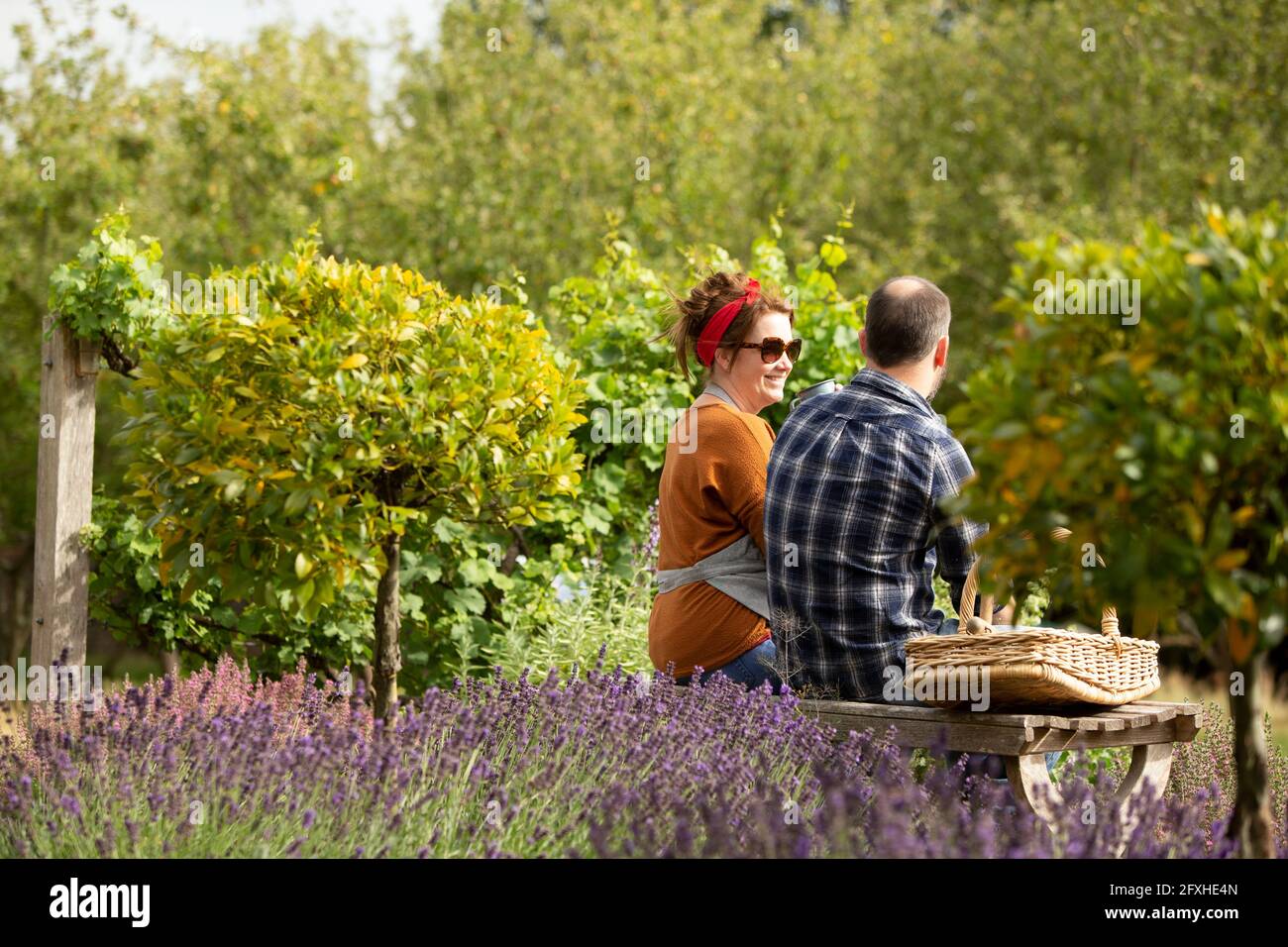 Couple prenant une pause de jardinage dans le jardin ensoleillé d'été Banque D'Images Couple prenant une pause de jardinage dans le jardin ensoleillé d'été Banque D'Images