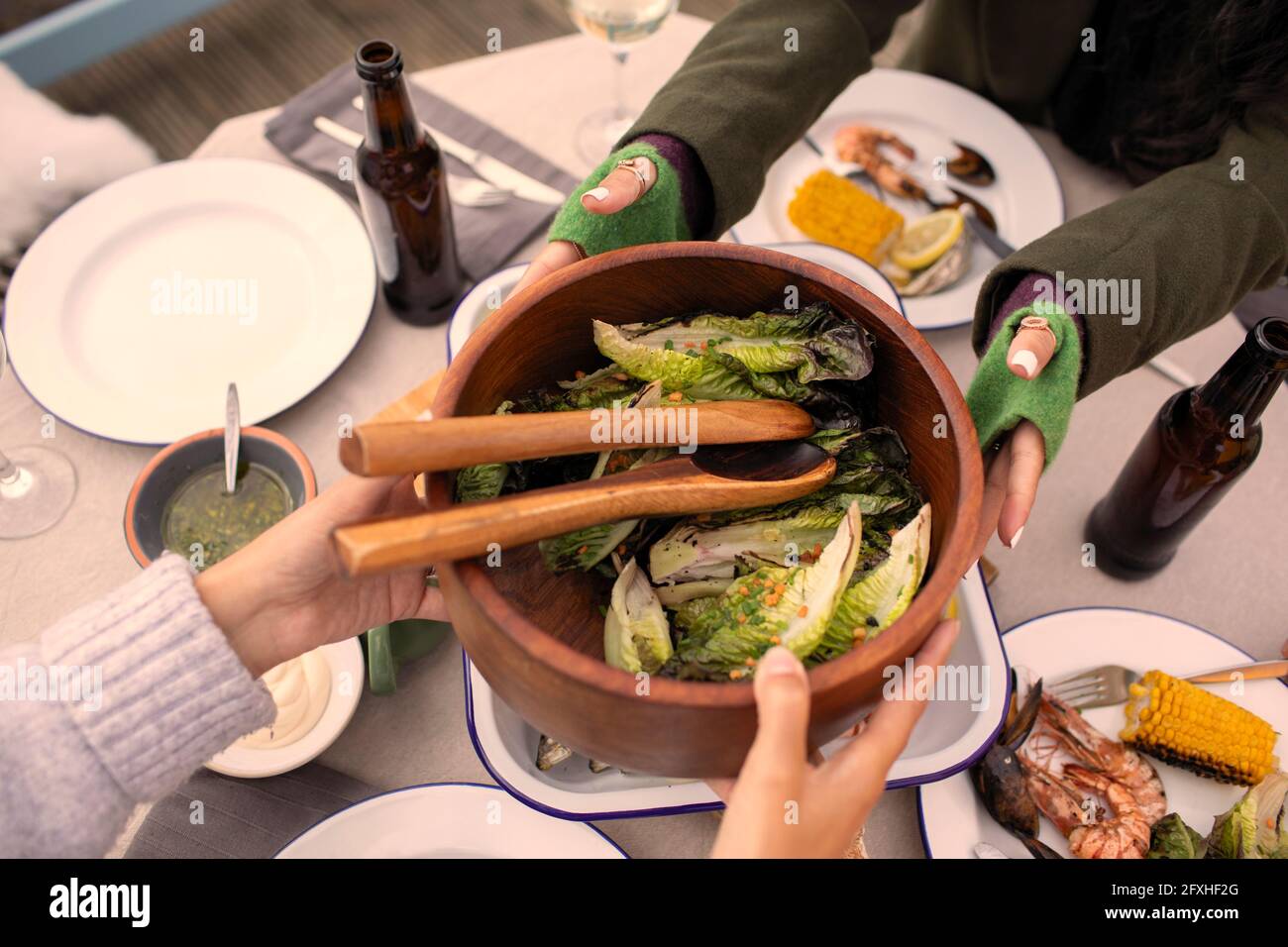 Des amis passent une salade sur une table de jardin Banque D'Images