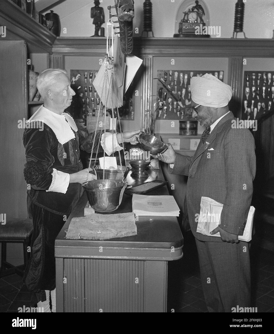 Congrès mondial du tabac. Un Indien regarde dans un bol qui lui est offert par un homme en costume du XVIIe siècle, 17 septembre 1951, conférences, industrie du tabac, Pays-Bas, Agence de presse du XXe siècle photo, nouvelles à retenir, documentaire, photographie historique 1945-1990, histoires visuelles, L'histoire humaine du XXe siècle, immortaliser des moments dans le temps Banque D'Images