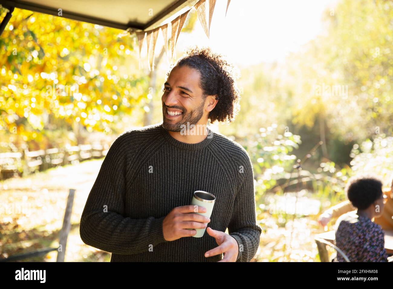 Un homme heureux avec un café dans un parc d'automne ensoleillé Banque D'Images