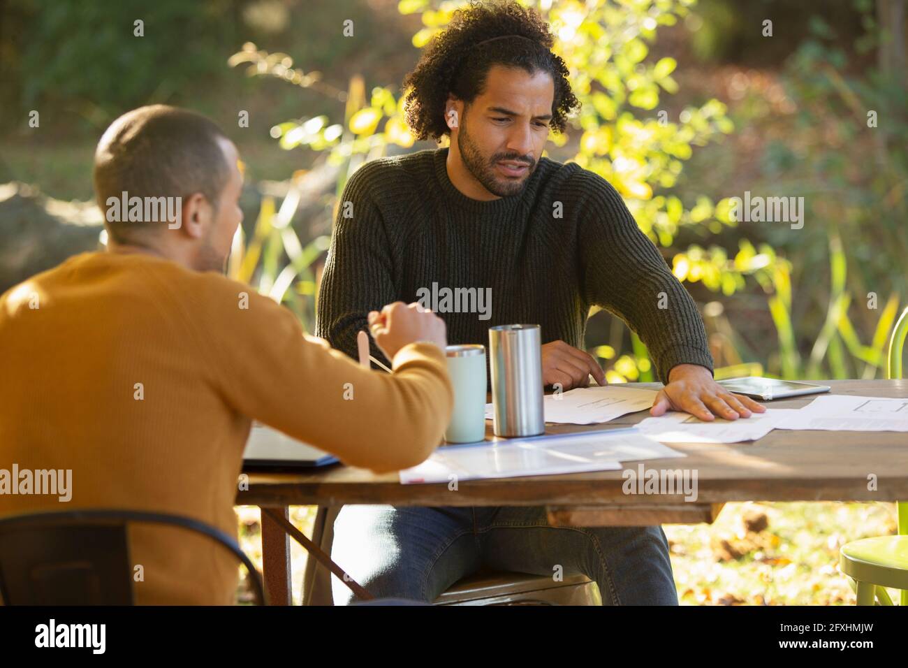 Les hommes d'affaires discutent de la paperasse à table dans le parc Banque D'Images