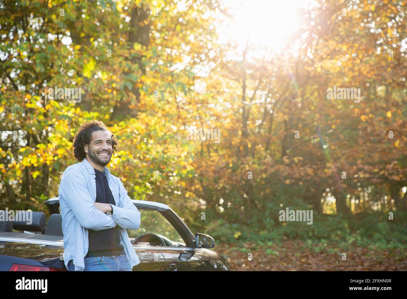 Joyeux homme au cabriolet dans un parc d'automne ensoleillé Banque D'Images