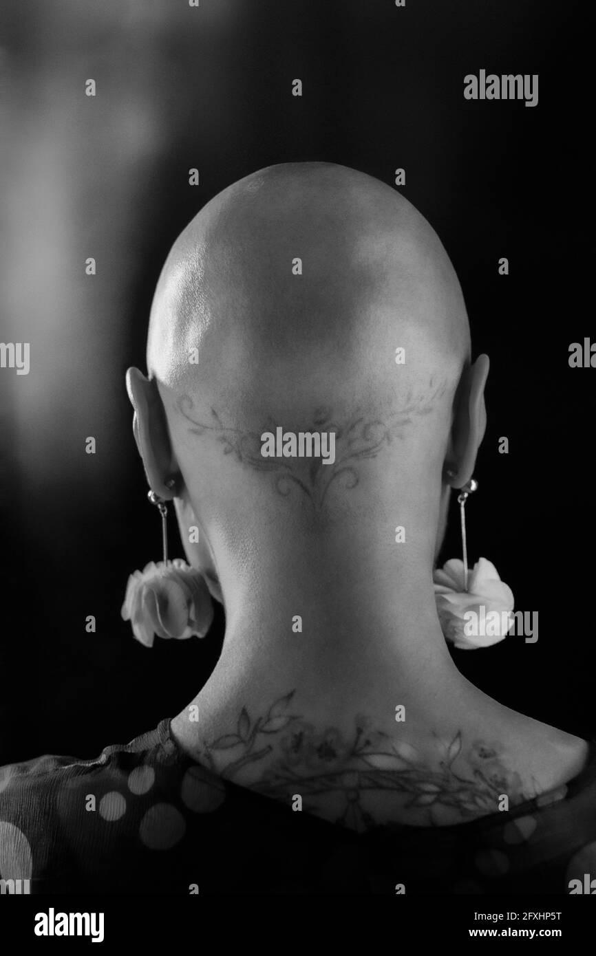 Gros plan femme élégante avec tête rasée et tatouages Banque D'Images