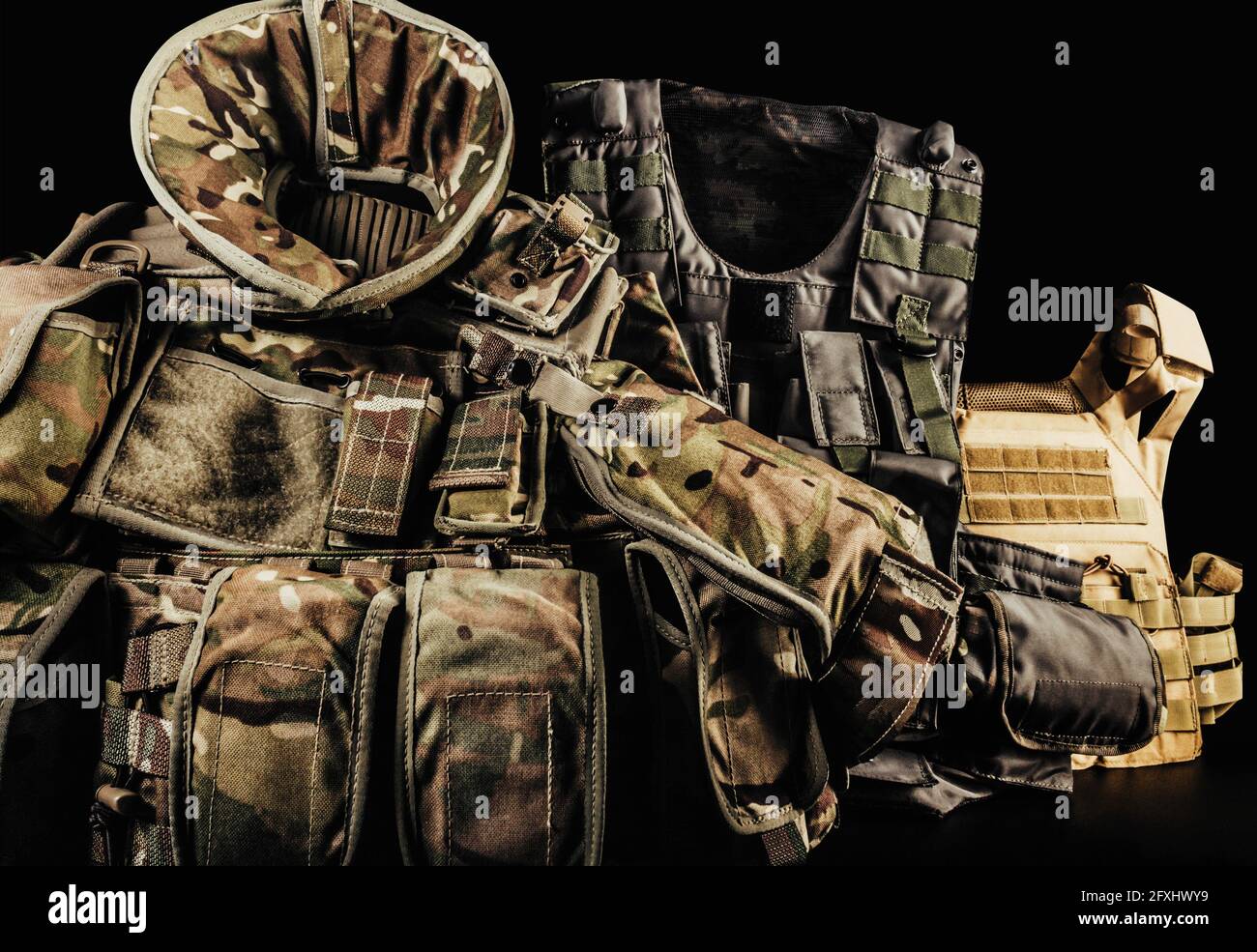 Divers types de soldat camouflage gilets blindés avec protection des épaules et du cou sur fond noir posé sur la table. Banque D'Images