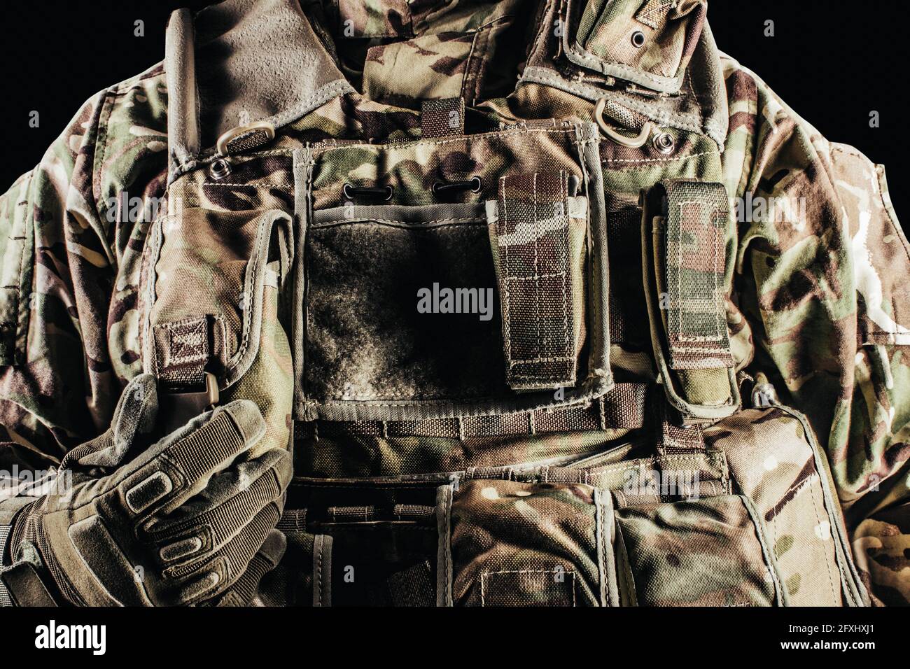 Photo d'un soldat dans un gilet blindé camouflé de niveau 3 sur fond noir. Banque D'Images