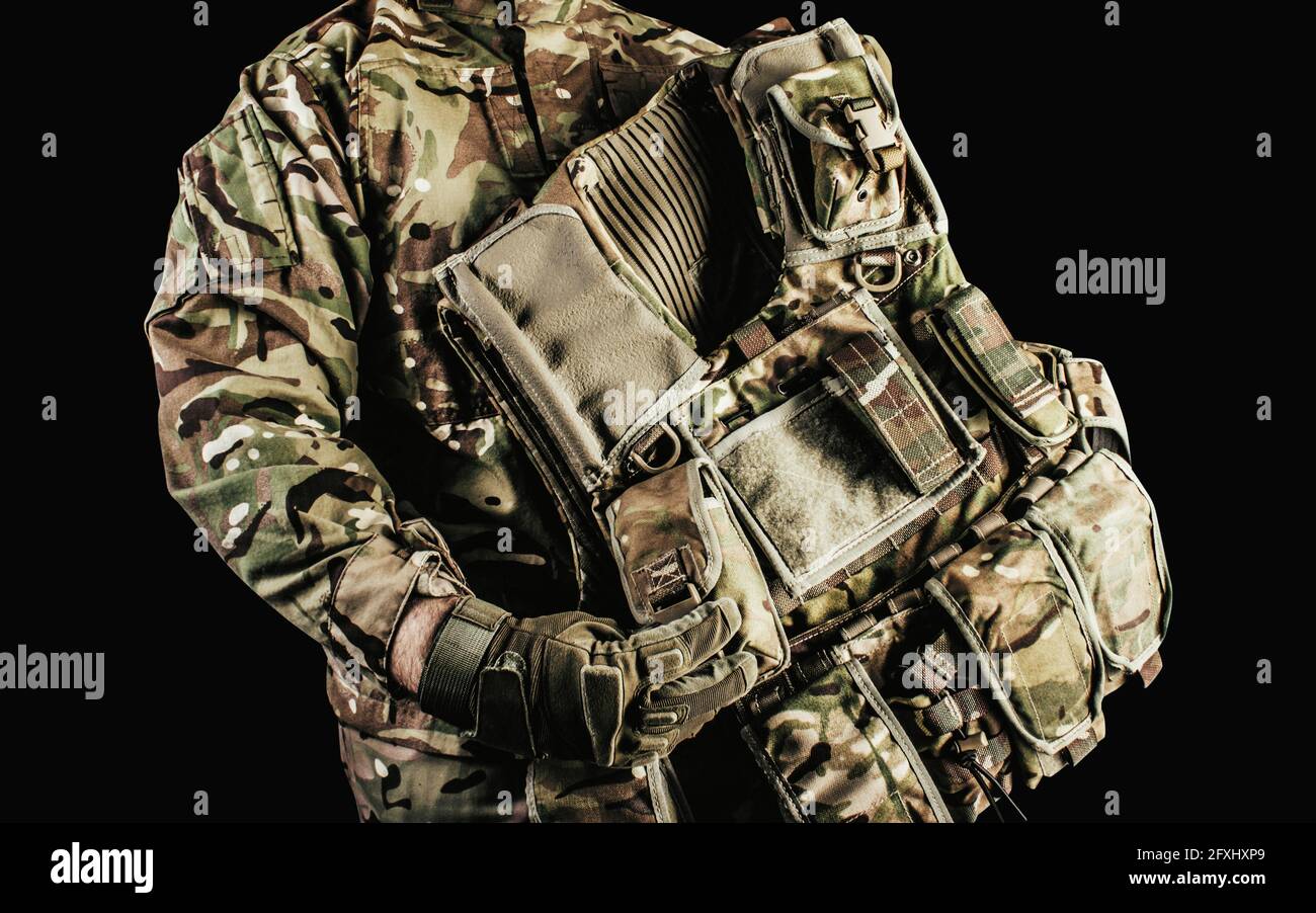 Photo d'un soldat portant un gilet blindé camouflé de niveau 3 avec protection des épaules et du cou sur fond noir. Banque D'Images