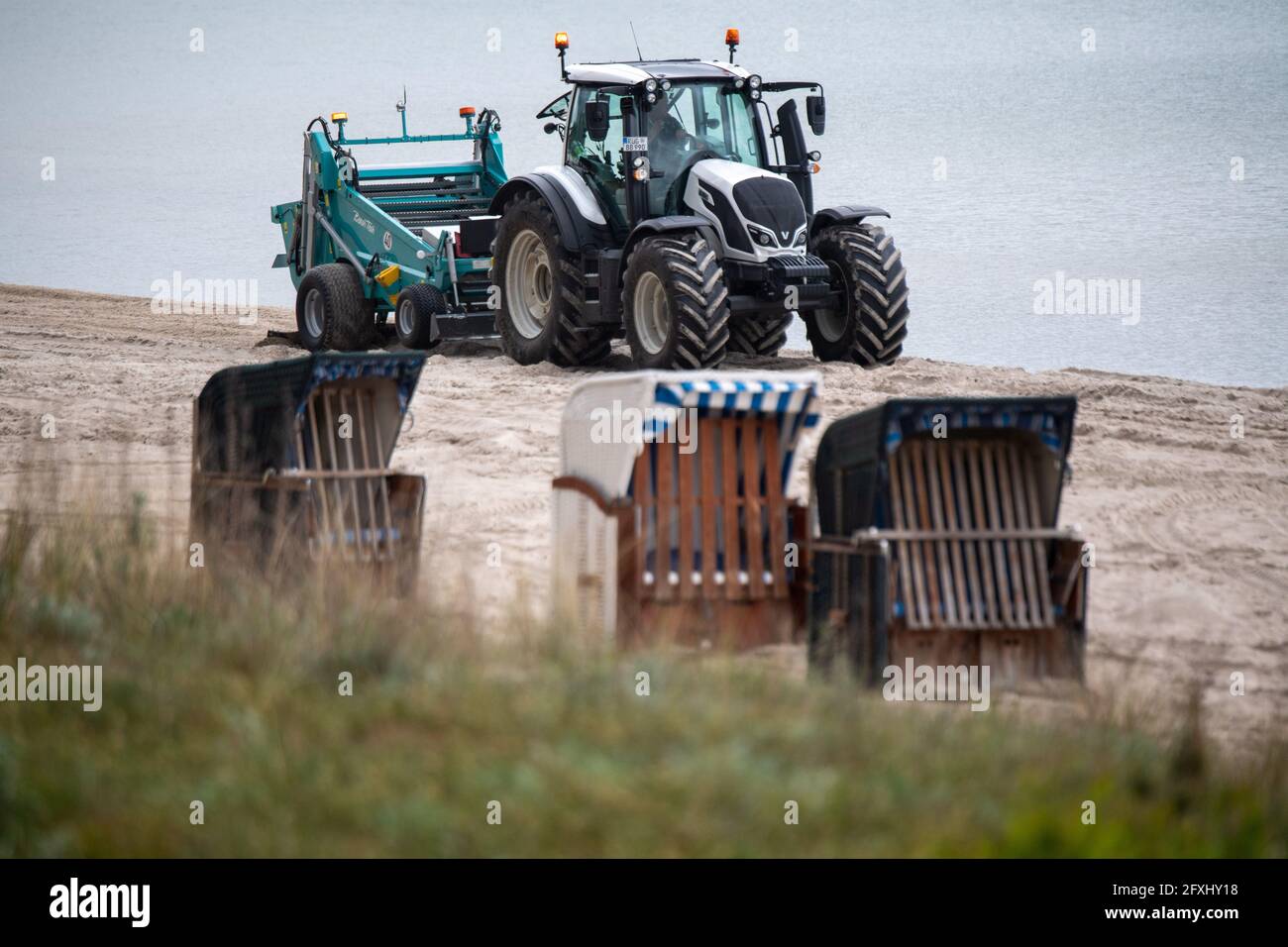Binz, Allemagne. 27 mai 2021. Un tracteur avec un râteau surdimensionné  nettoie la plage de la station balnéaire Baltique de Binz sur l'île de  Rügen. L'appareil grille le sable et recueille toutes