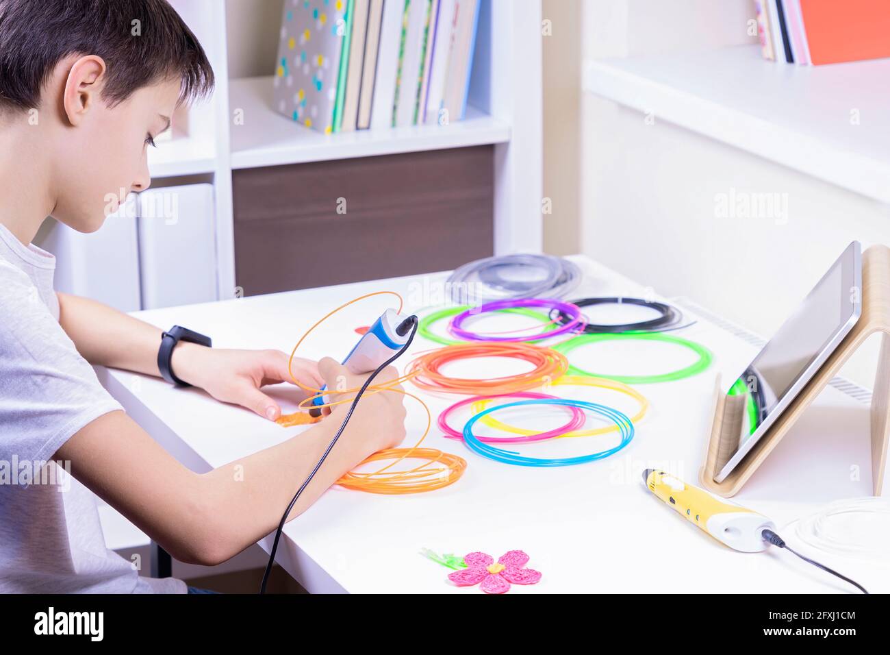 Enfant créant un nouvel objet 3D avec un stylet 3d. Apprentissage, technologie, éducation STEM, loisirs, divertissement créatif à la maison Banque D'Images