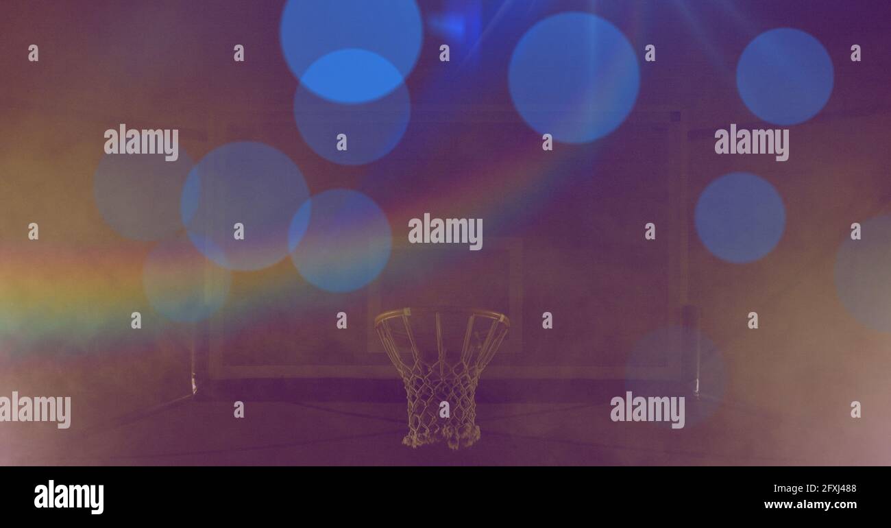 Composition d'un panier de basket-ball avec des points bleus de lumière avec prisme sur fond jaune teinté Banque D'Images