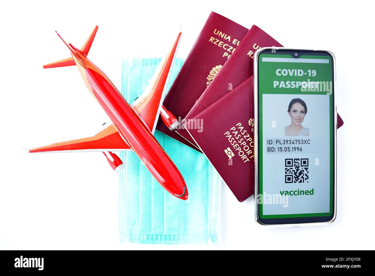 Voyager pendant la pandémie du COV-19 du SRAS. Passeport traditionnel, masque, avion jouet et demande de passeport Covid-19 dans le téléphone mobile. Banque D'Images