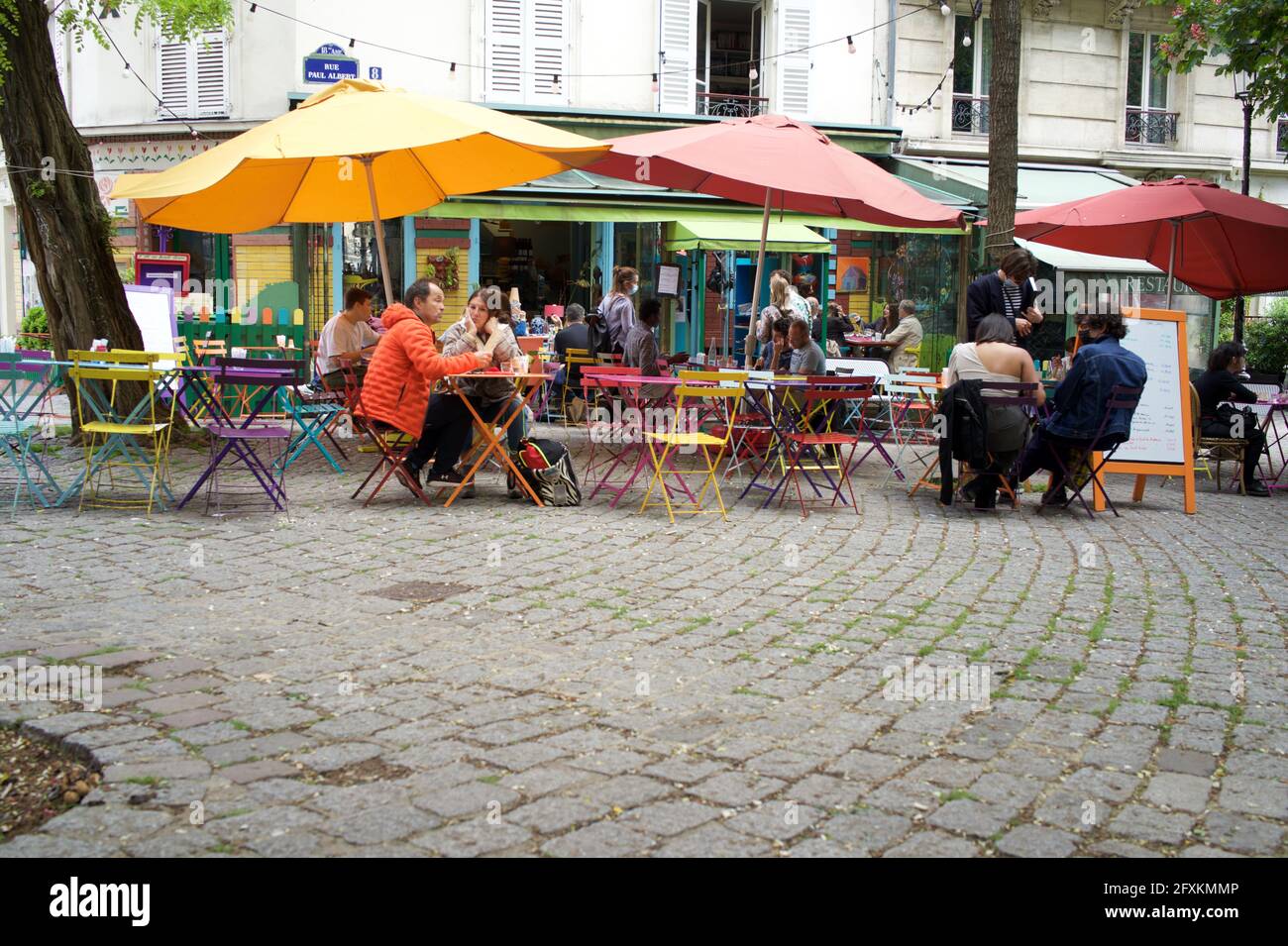 Les clients peuvent prendre un verre sur une terrasse de café colorée à Montmartre, l'une des nombreuses terrasses de cafés parisiens désormais ouvertes au public après que Covid-19 a été assouplie - l'été en pente douce, 8 rue Paul Albert, 75018, Paris, France. Mai 2021. Banque D'Images