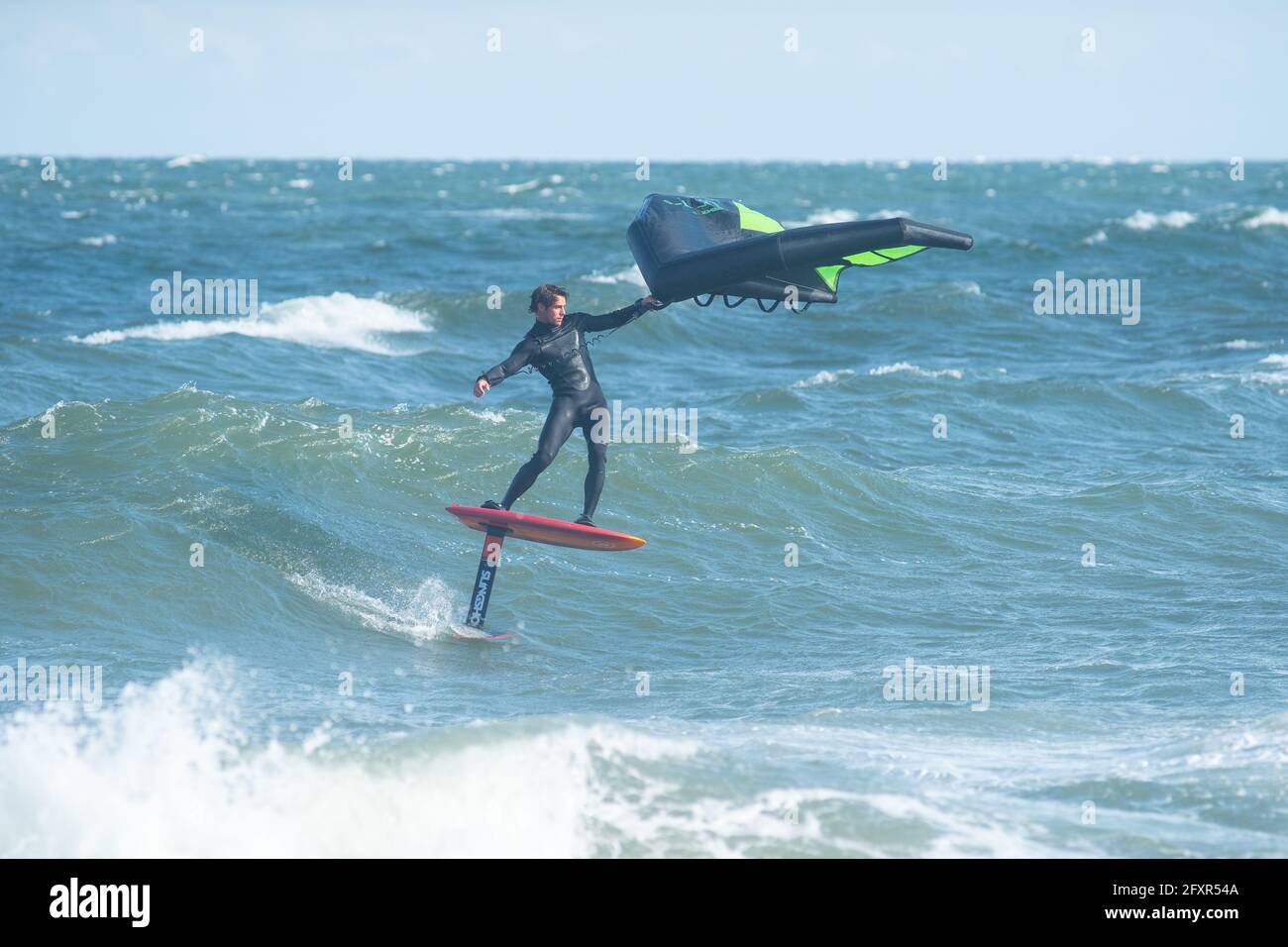 Le surfeur professionnel James Jenkins surfe surfe une vague sur son escadre surfeur dans l'océan Atlantique à Nags Head, Caroline du Nord, États-Unis, Amérique du Nord Banque D'Images