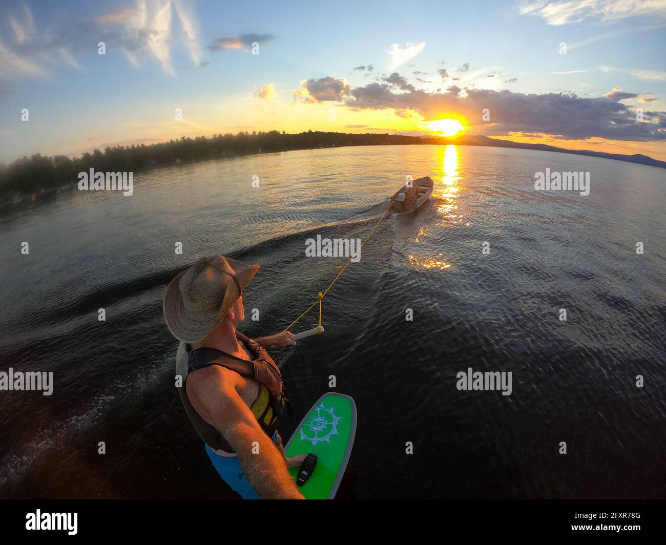 Le photographe Skip Brown travaille derrière un petit bateau au coucher du soleil sur le lac Sebago, Maine, États-Unis d'Amérique, Amérique du Nord Banque D'Images