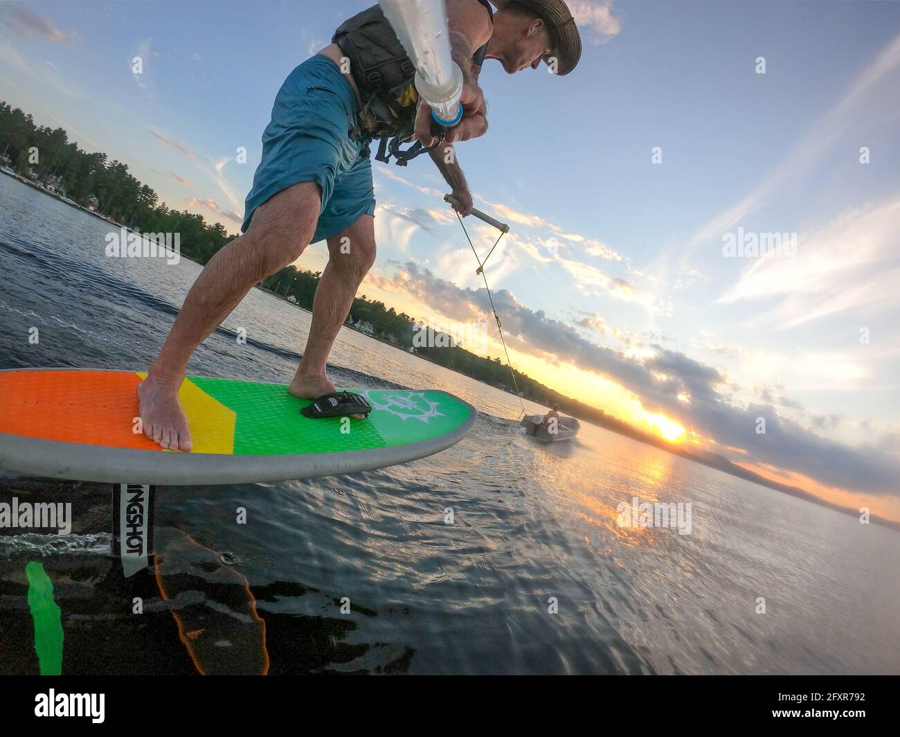 Le photographe Skip Brown travaille derrière un petit bateau au coucher du soleil sur le lac Sebago, Maine, États-Unis d'Amérique, Amérique du Nord Banque D'Images