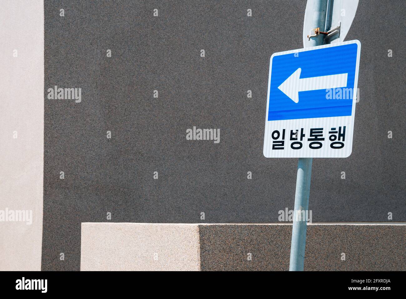 Panneau de signalisation à sens unique et mur gris en Corée Banque D'Images