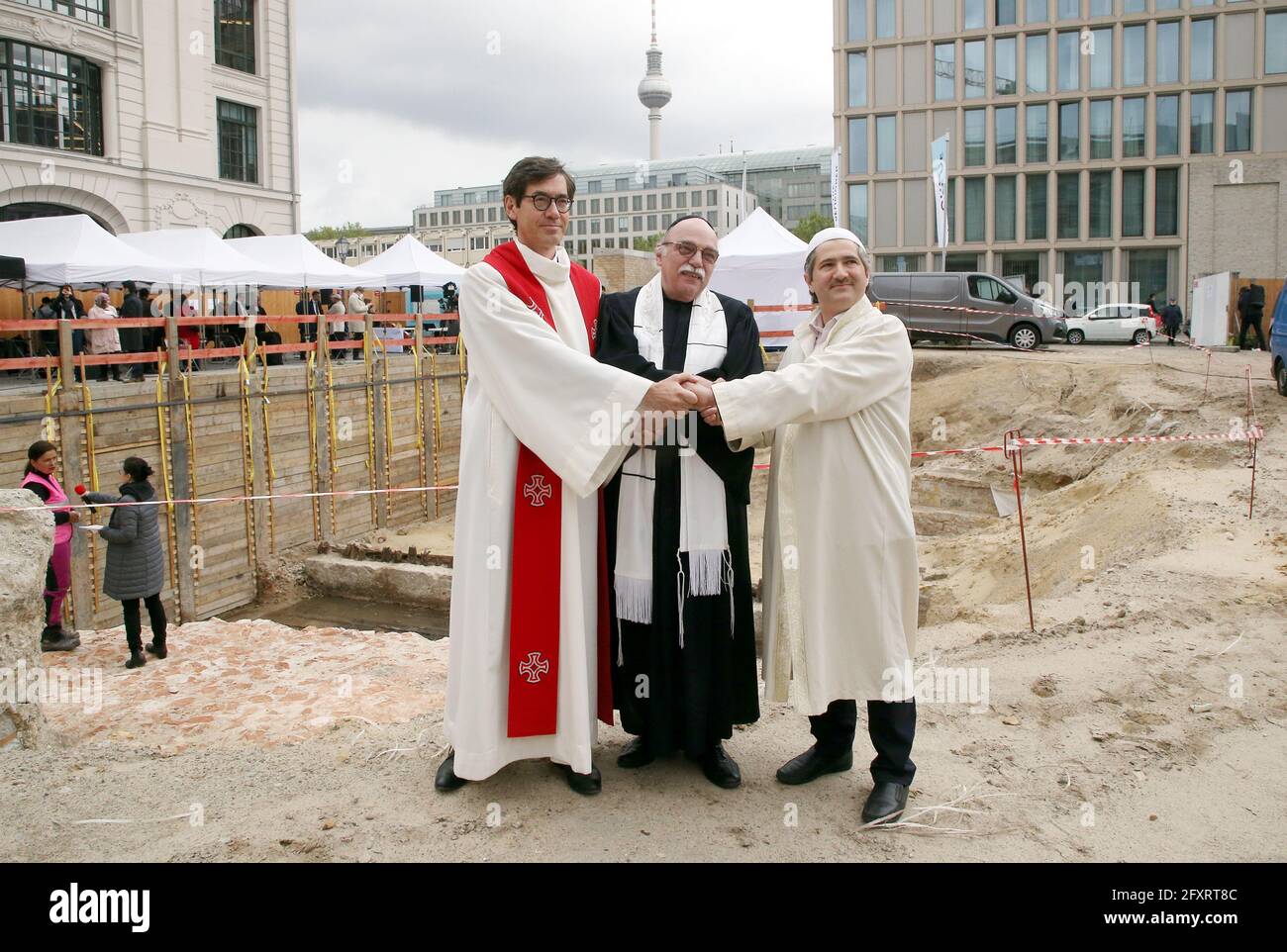 Berlin, Allemagne. 27 mai 2021. Übersetzung Serbisch Pfarrer Gregor Hohberg (l-r), Rabbiner Andreas Nachama und Imam Kadir Sanci stehen im Berliner Bezirk Mitte vor den Resten der im Krieg zerstörten Petrikirche und nehmen an der Grundsteinlegung für das Mehrionengebäude Berlin "Maison religieuse". Mit dem House of one entsteht ein Sakralbau mit einer Synagoge, einer Kirche und einer Moschee unter einem Dach. Credit: Wolfgang Kumm/dpa/Alay Live News Banque D'Images