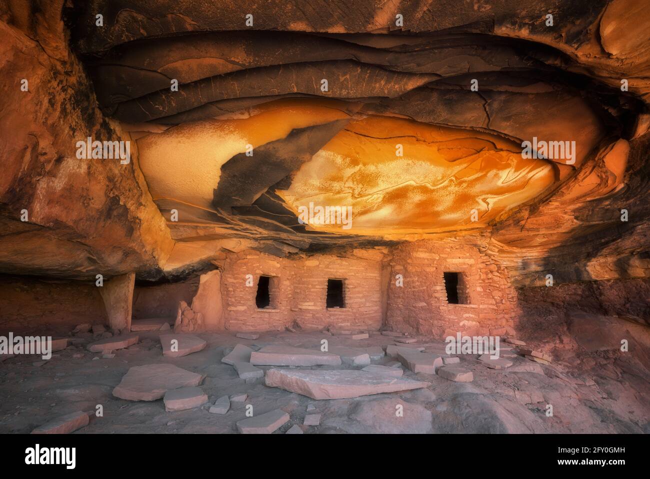 La lumière du soleil réfléchissante illumine le plafond de cet ancien grenier Anasazi et porte le nom de « Falling Roof Ruin dans le plateau de Cedar Mesa, dans l'Utah du Sud-est. Banque D'Images