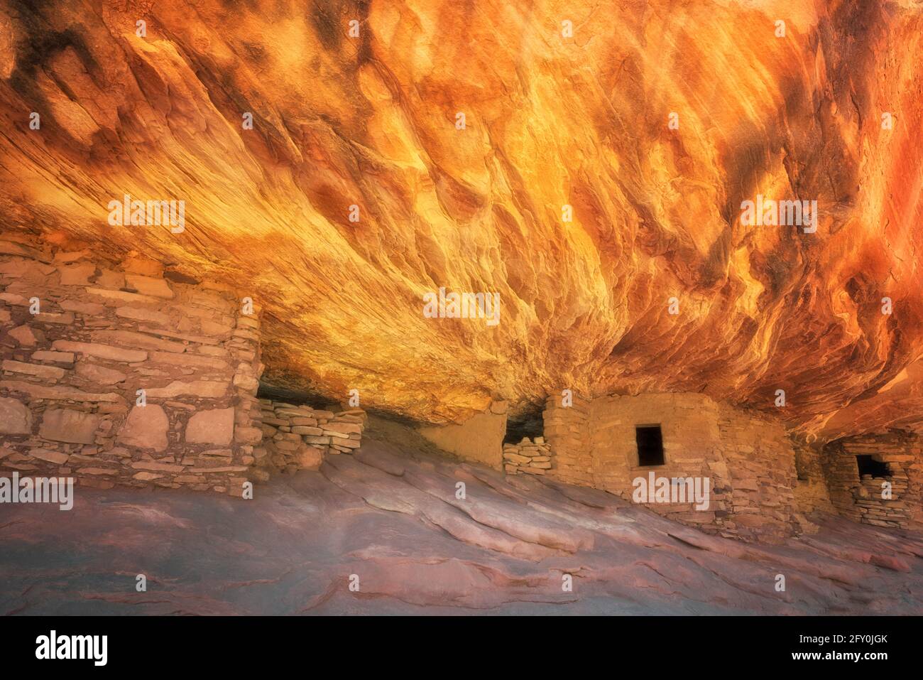 La lumière du soleil réfléchissante illumine la roche de grès au-dessus de cet ancien Anasazi Granary et bien nommé House on Fire Ruin Cedar Mesa PL, dans l'Utah du Sud-est Banque D'Images
