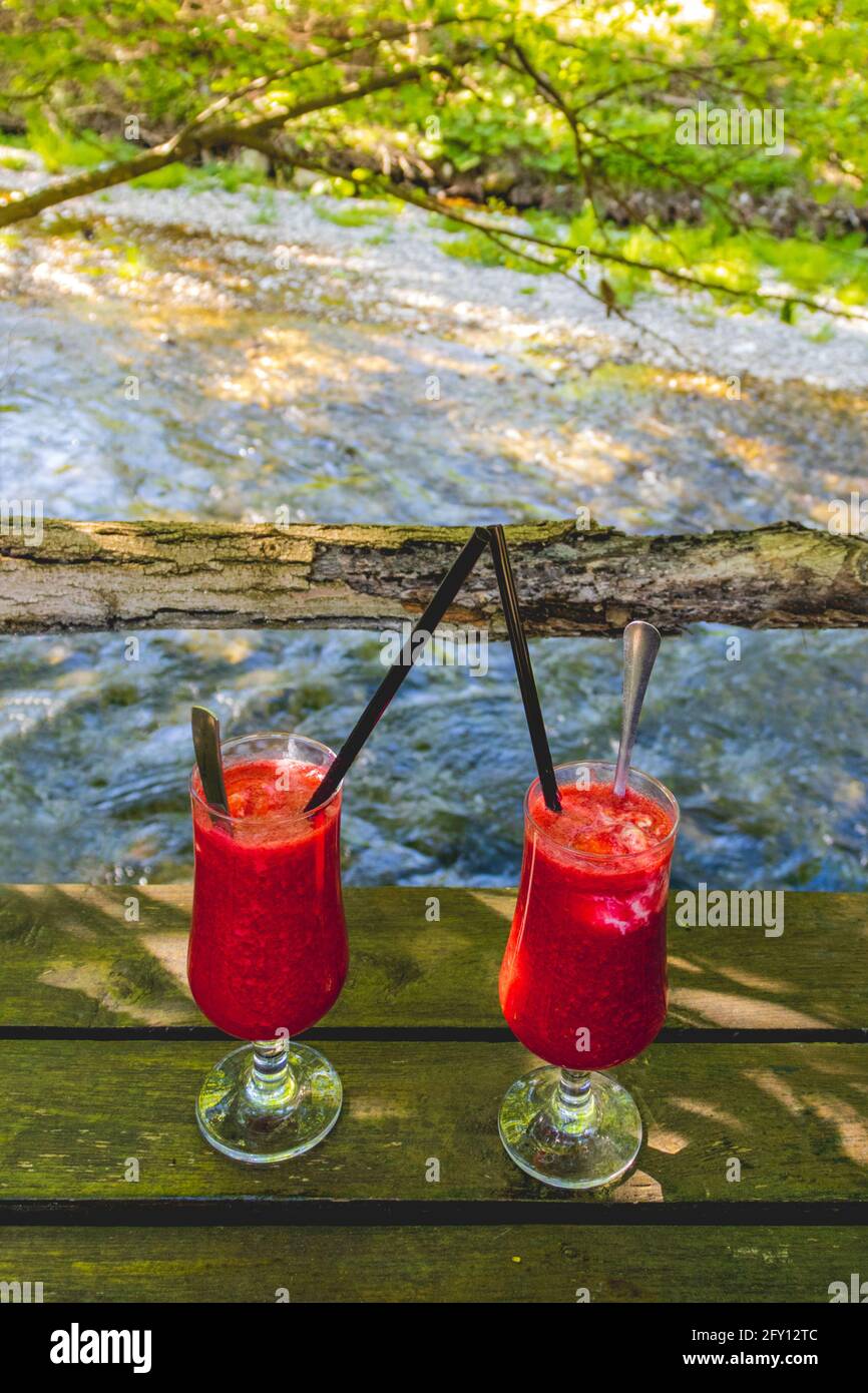 Deux boissons avec framboises sur une rive de rivière Banque D'Images