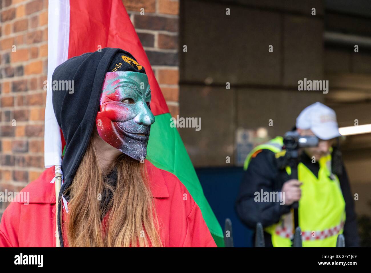Manifestant dans un masque bloquant la caméra vidéo de la police avec drapeau, Free Palestine Protest, Ambassade d'Israël, Londres, 22 mai 2021 Banque D'Images