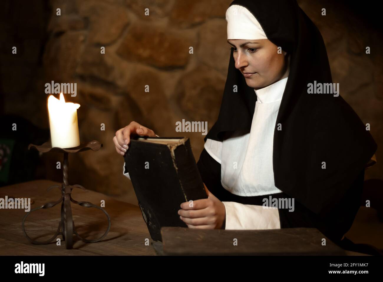 Jeune nun pensif avec vieille bible dans le vieux monastère Banque D'Images