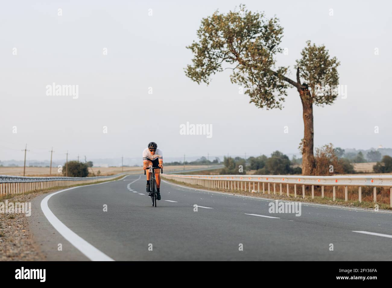 Cycliste actif utilisant le vélo pour l'entraînement sur route pavée Banque D'Images