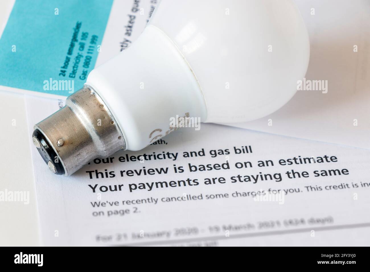 Image concept d'une lampe électrique à baïonnette sur un estimation de la facture combinée de gaz et d'électricité Banque D'Images