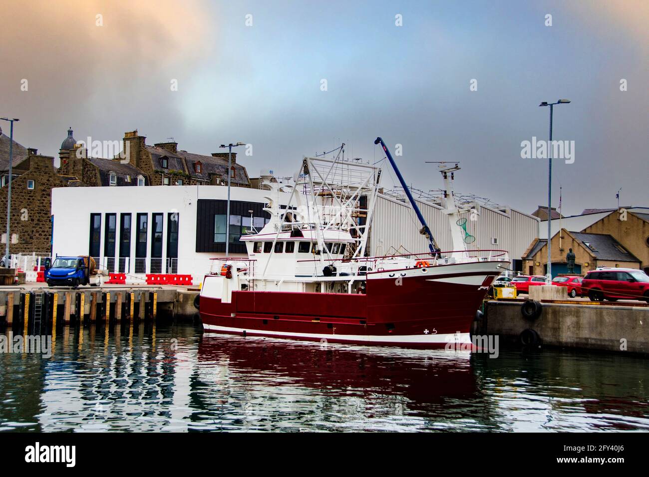 Bateau de pêche avec bâtiment Windfarm en arrière-plan à Fraserburgh Harbour, Aberdeen, Écosse, Royaume-Uni Banque D'Images