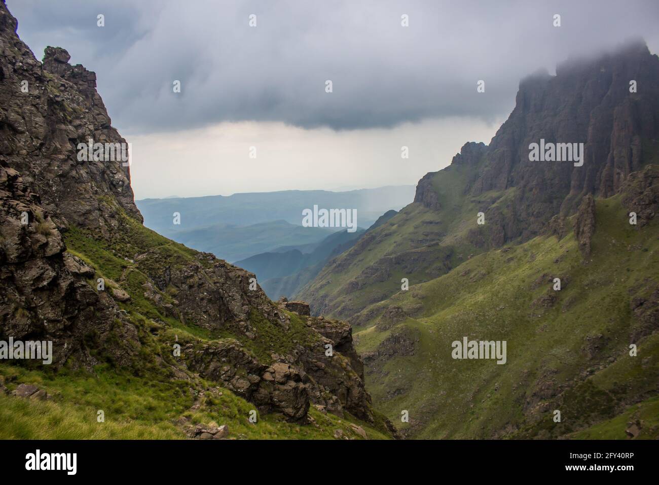 Entre les falaises des montagnes du Drakensberg, le long de la frontière entre l'Afrique du Sud et le Lesotho, avec des nuages de tempête qui s'élèvent au-dessus. La vite cha Banque D'Images