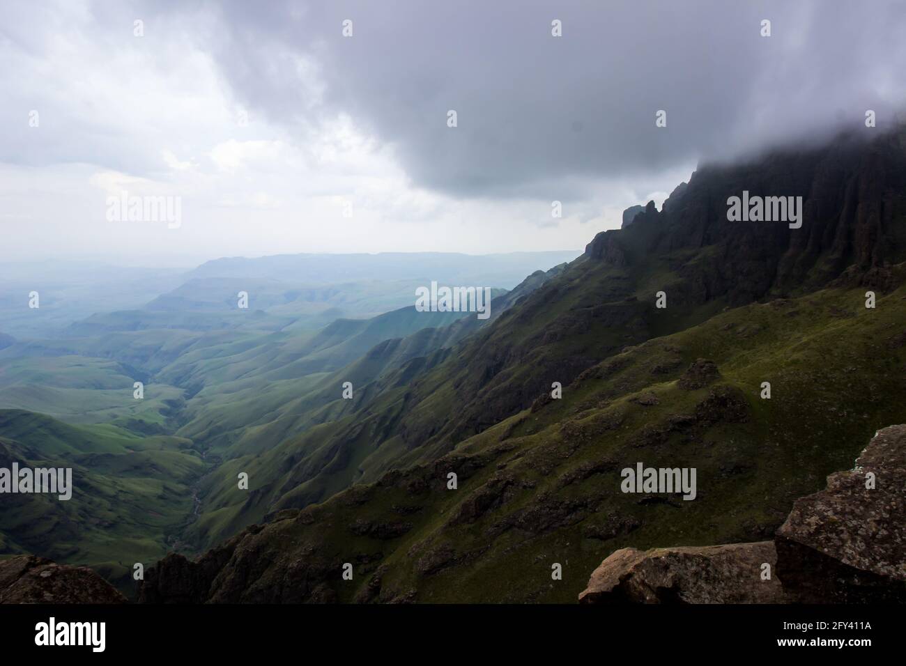 Vue sur une vallée isolée dans les montagnes du Drakensberg en Afrique du Sud, avec les hauts sommets cachés par les nuages de tempête de rassemblement. La vite cha Banque D'Images