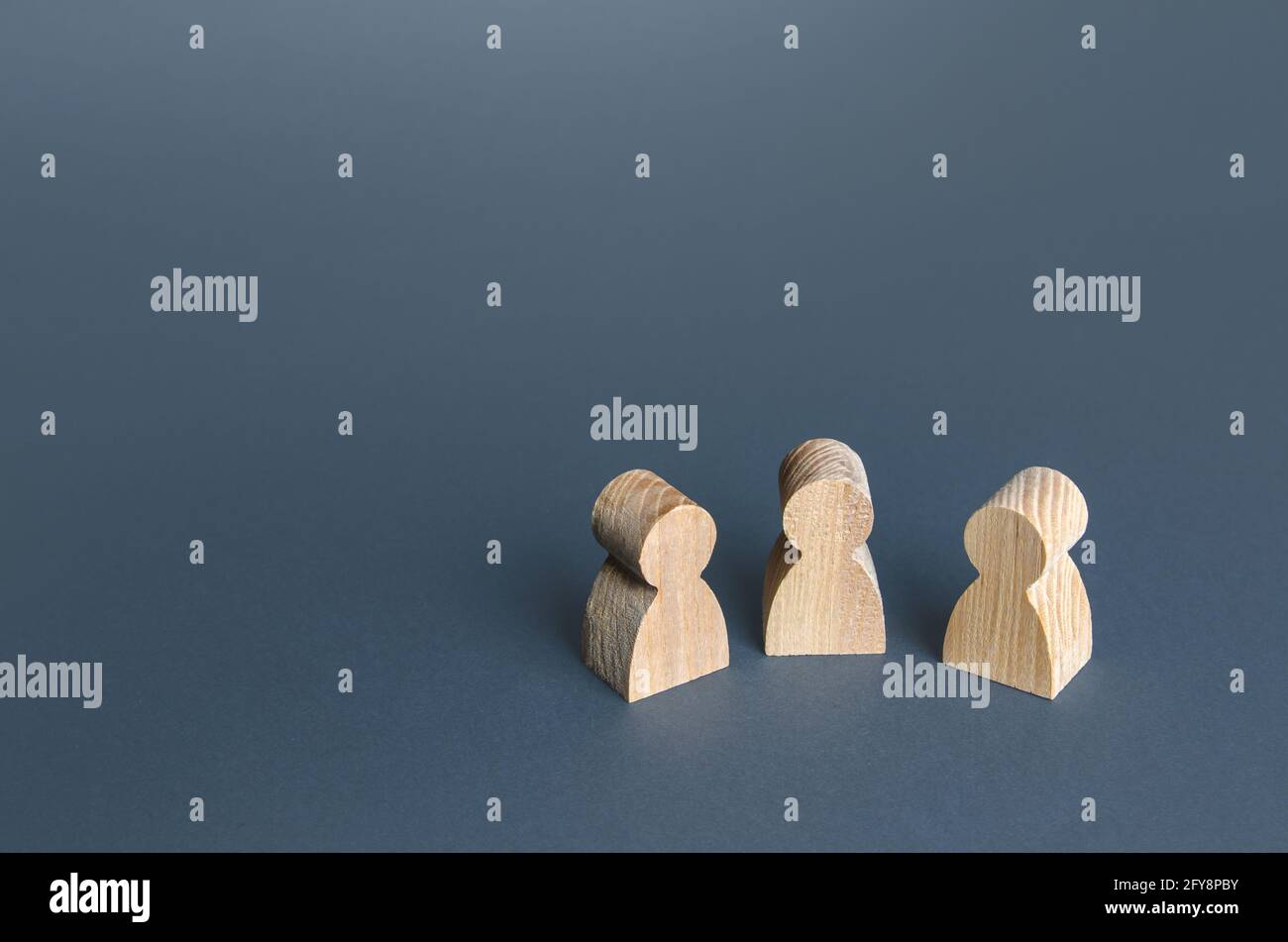 Trois figurines humaines. Communication et discussion. Relations amicales. Une réunion. Assistance, coopération et collaboration. Banque D'Images
