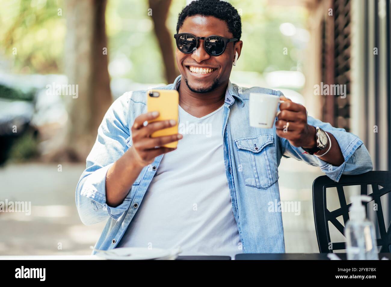 Homme en conversation vidéo avec un téléphone portable dans un café. Banque D'Images