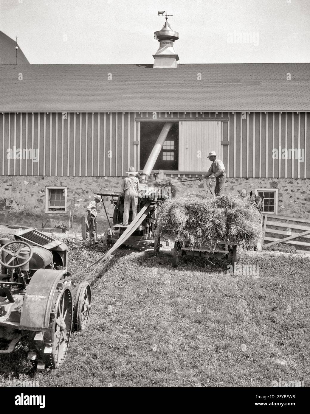 Années 1920 années 1930 années 1940 TROIS OUVRIERS AGRICOLES CHARGENT DU FOIN DANS GRANGE À L'AIDE DE FOURCHES ET D'UN CONVOYEUR MÉCANIQUE D'ENTRAÎNEMENT PAR COURROIE DU TRACTEUR - F3937 HAR001 ROUES HARS MÉCANIQUE HOMME SENIOR TRANSPORT SENIOR ADULTE AGRICULTURE D'ÂGE MOYEN B&W AMÉRIQUE DU NORD HOMME D'ÂGE MOYEN CHARGEANT LE NORD L'OCCUPATION DES COMPÉTENCES AMÉRICAINES FAIT DES MAMMIFÈRES ET DES AGRICULTEURS EXTÉRIEURS UN VERS OCCUPATIONS UTILISANT LE MOUVEMENT BLUR CUPOLA CONVOYEUR WAGONS COOPÉRATION MACHINES AGRICOLES HAYLOFT K3 MAMMIFÈRE NOIR ET BLANC RACE BLANCHE HAR001 OLD À LA MODE Banque D'Images