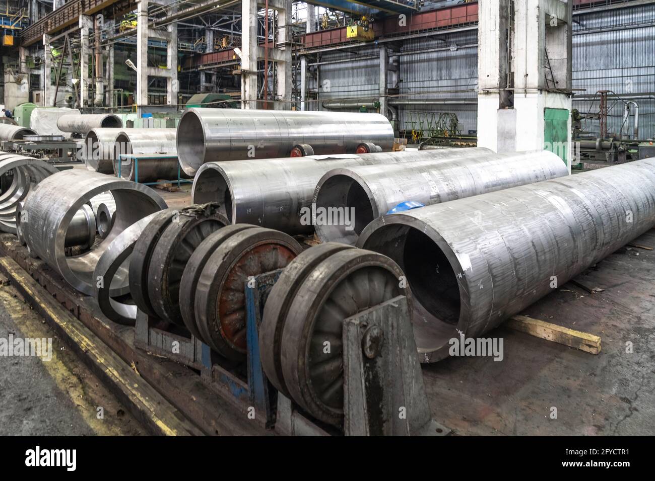 Ligne de production d'usine de tuyaux avec tuyaux tubulaires en acier sur le plancher, industrie lourde de travail des métaux. Banque D'Images