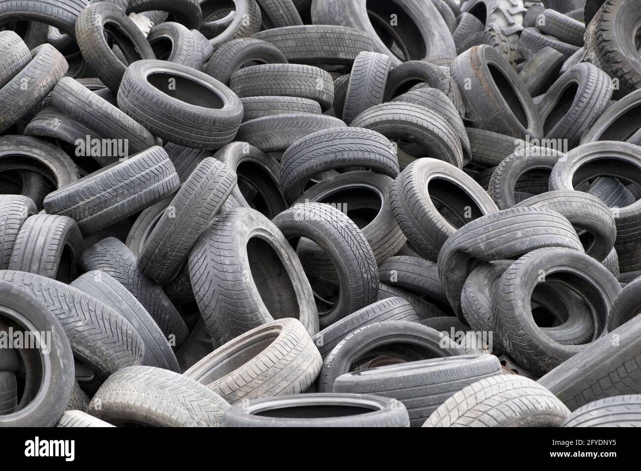 Tas de pneus usagés lourds. Vieux pneus de voiture empilés recyclent le concept de caoutchouc Banque D'Images