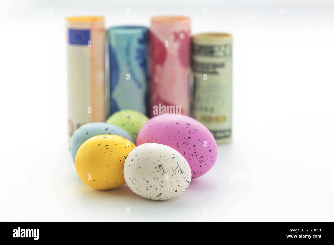 Les concepts commerciaux et financiers se reflètent dans des symboles de diversification différents devises internationales et cinq œufs colorés sur fond blanc Banque D'Images