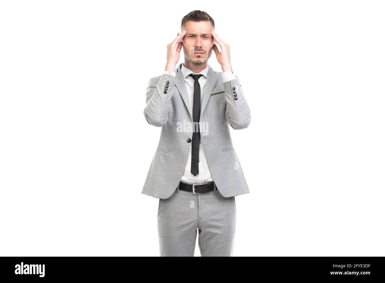 Portrait horizontal moyen d'un jeune adulte élégant travailleur de bureau caucasien portant un costume gris ayant des maux de tête de tension, fond blanc Banque D'Images